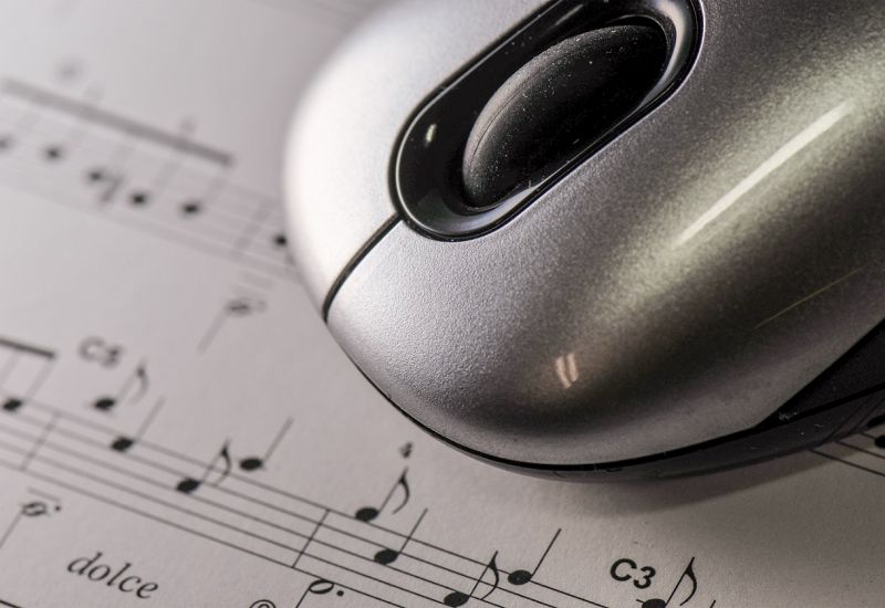 Computer mouse on top of sheet music.