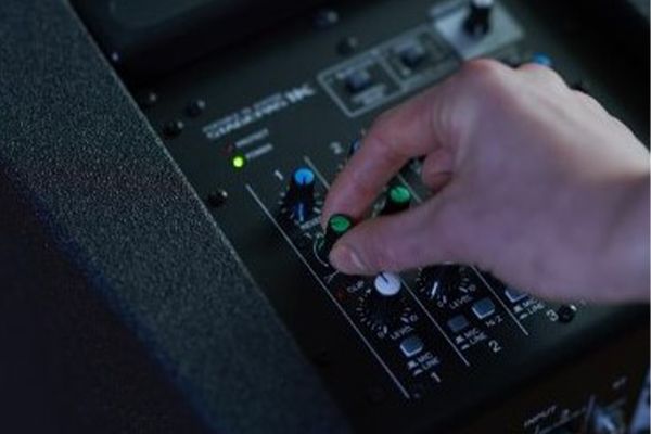 Hand adjusting dial on Yamaha STAGEPAS mixer.