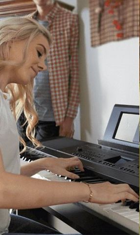 A young woman playing a piano.