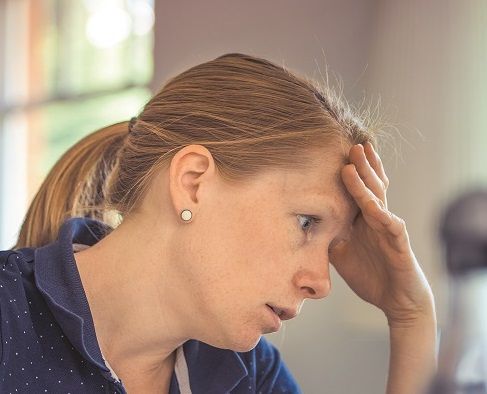 overwhelmed woman with hand on her forehead