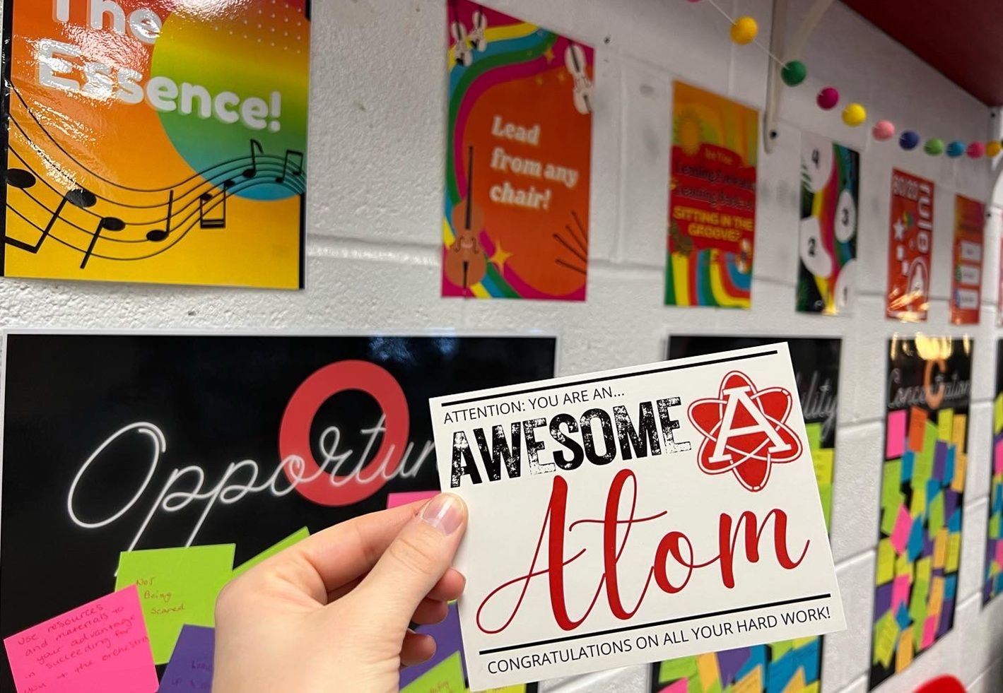 hand holding card saying "Awesome Atom" for student recognition