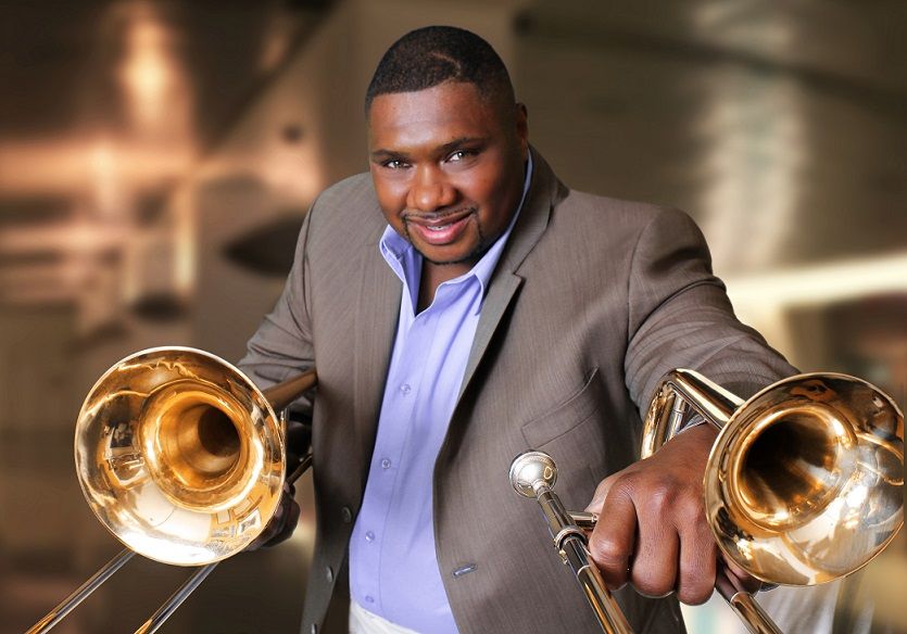 Wycliffe Gordon holding two trombones