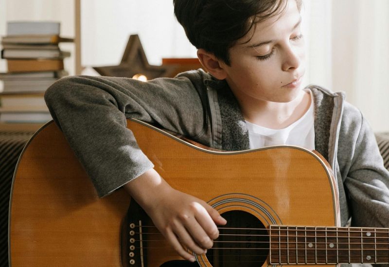 male student playing guitar