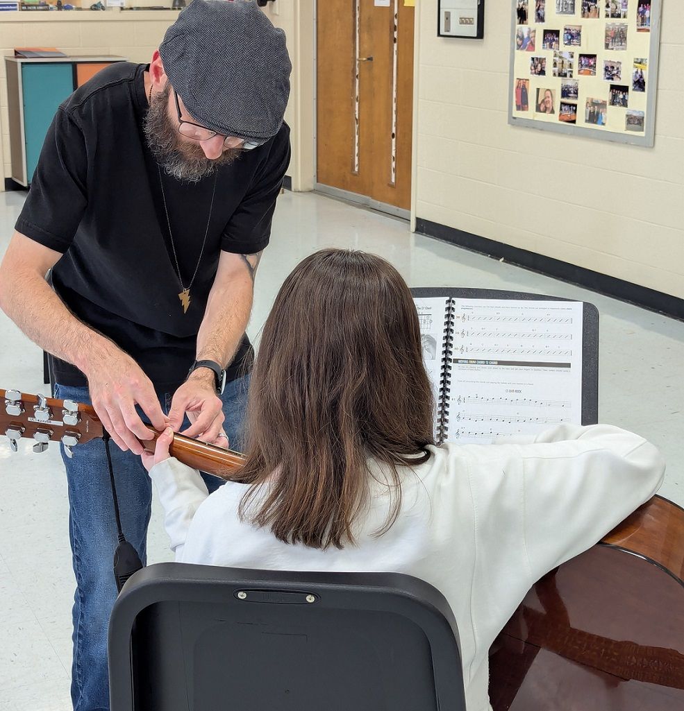 Jacob Abbot helping student on guitar