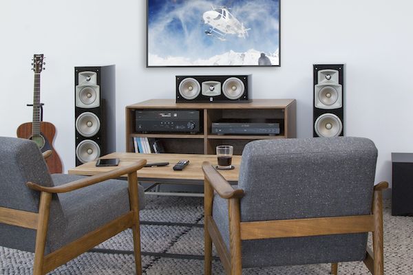 Modern living room with large flat screen with a variety of speakers and elements for home theater.