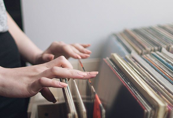 Woman leafing through stacks of albums.