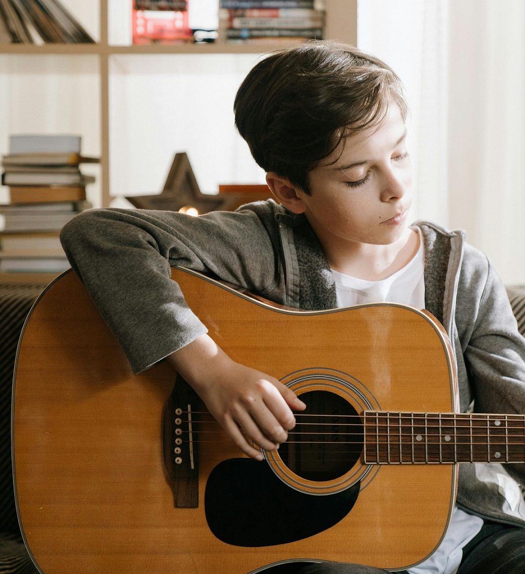 male student playing guitar