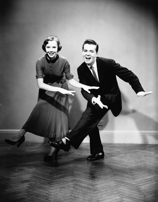 Young couple dancing in empty room, (B&W)