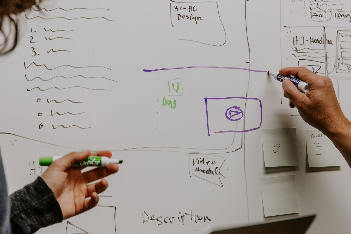 man and woman writing on white board