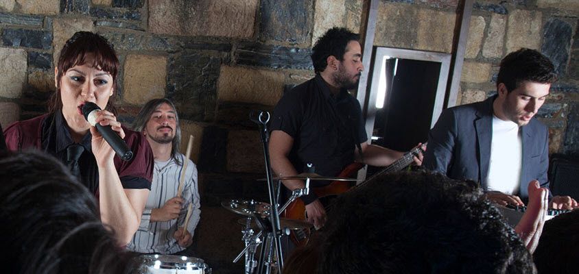 Band onstage in a small busy club.