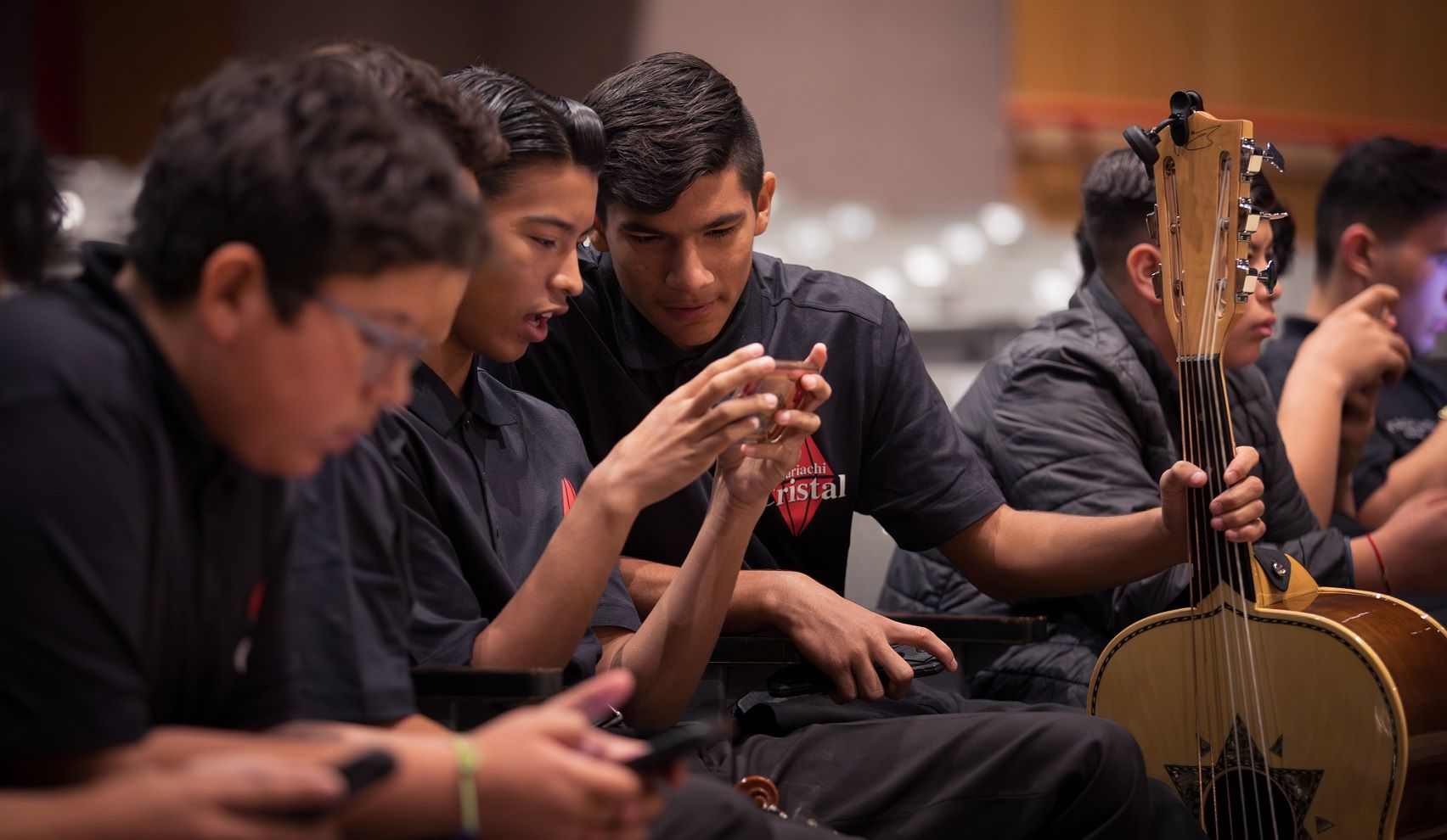 two band students looking at cell phone during rehearsal