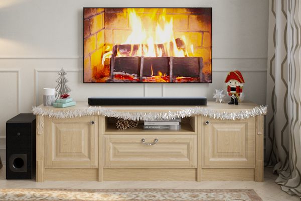 Holiday living room entertainment center with fireplace shown on television and sound bar.