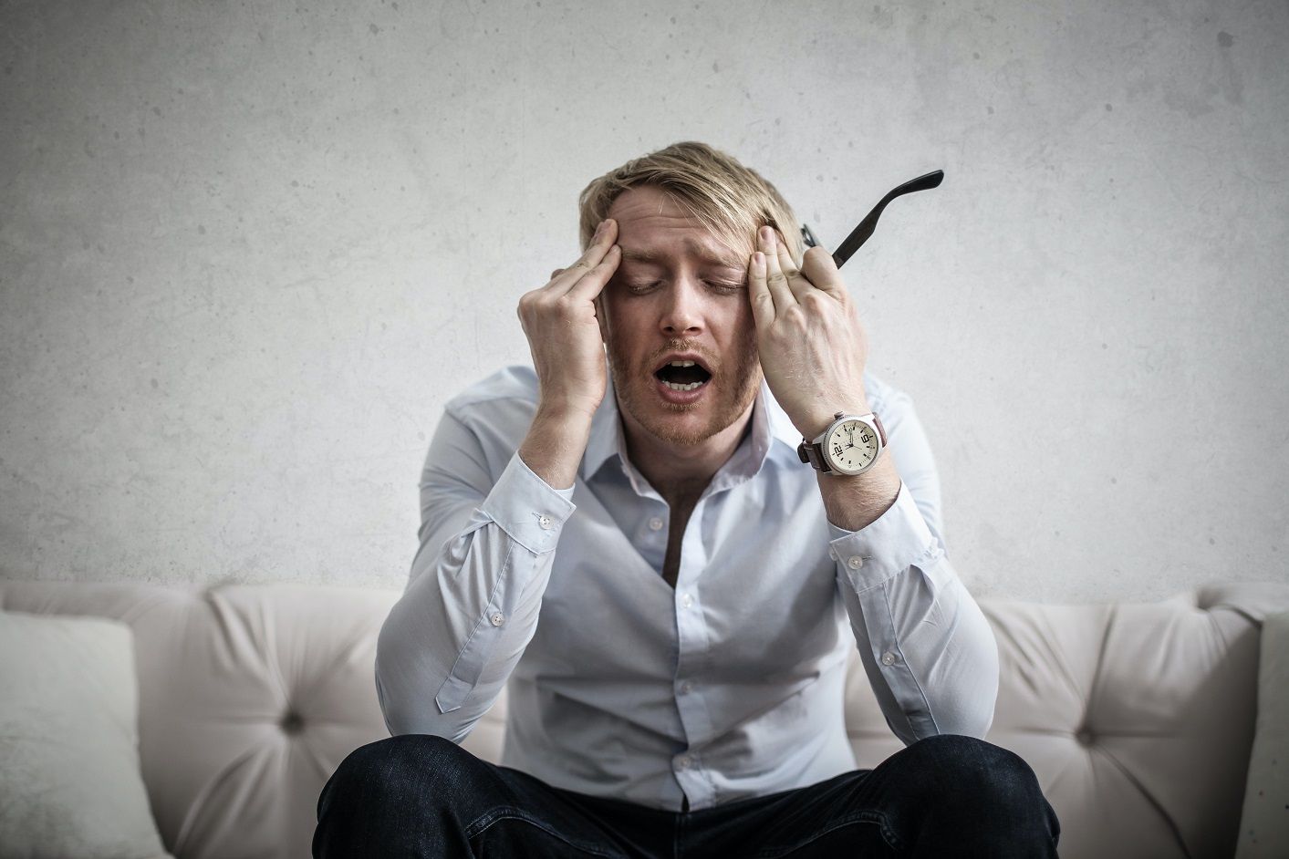 stressed out man with hands on temple