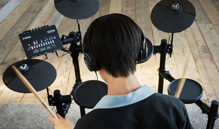 Youth practicing on an electronic drum kit.