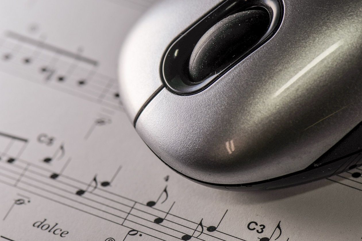 Computer mouse on top of sheet music.