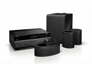 Group of sound components, including a receiver, a couple of small cylindrical speakers, an oblong speaker and a subwoofer.