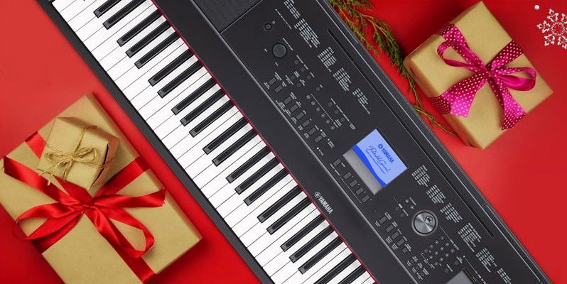 Yamaha keyboard on a flat surface wrapped in holiday paper.