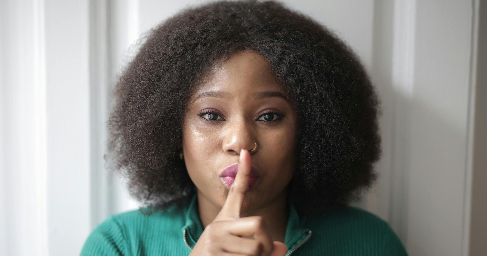woman holding finger to her lips
