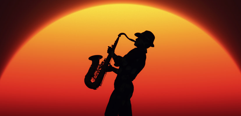 Sunset behind the profile of a man playing a saxophone.