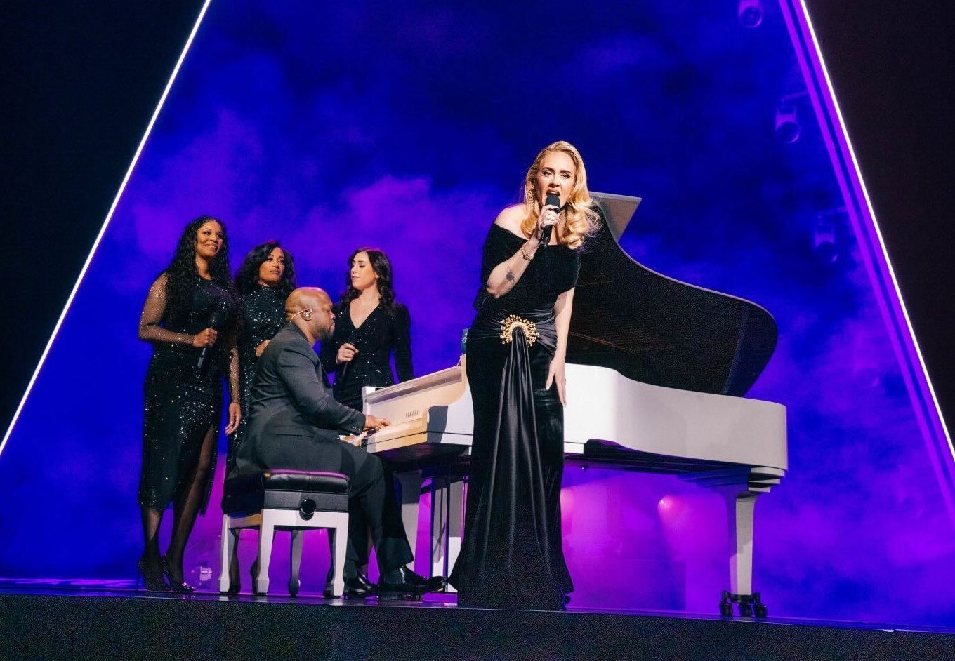 A pianist onstage with singer Adele and three backing singers.