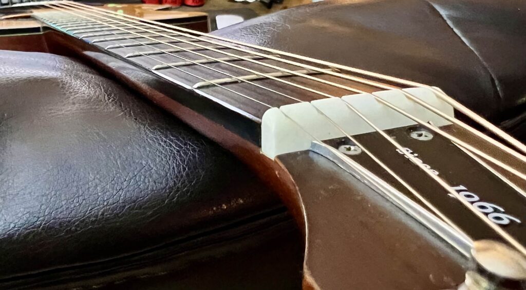 A guitar neck, seen from the headstock down on the treble side.