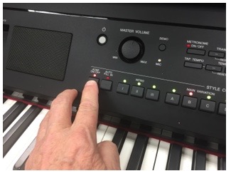 Finger touching a button on a Clavinova digital piano.