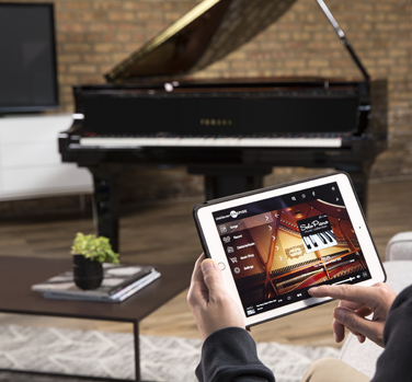 Disklavier Enspire with a person touching a tablet.
