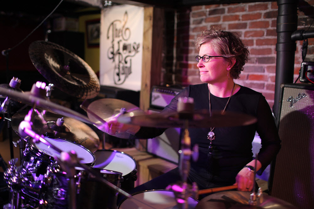 A woman playing drums.