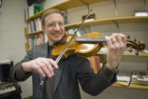 A smiling man with a violin.