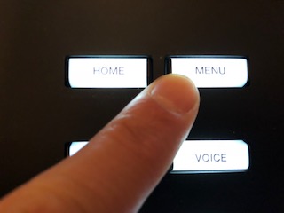 A finger pressing the menu button.