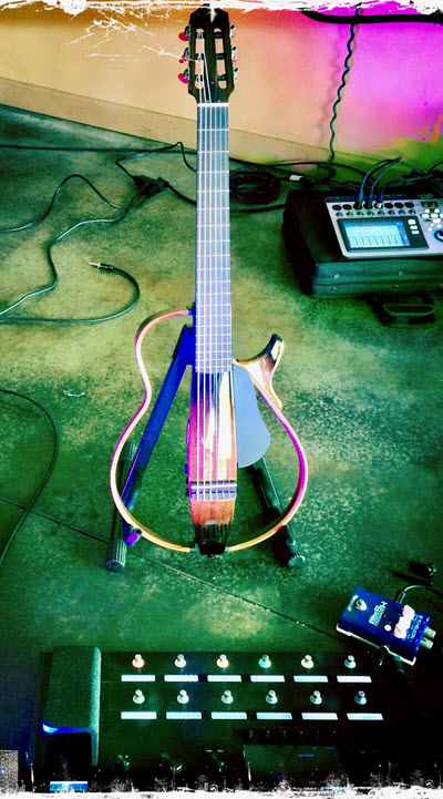 Stylized image of an electric guitar with clear body on a guitar stand with control panel in foreground.