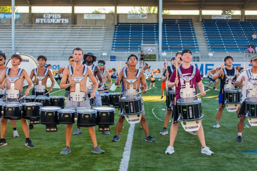 Students playing drums on field