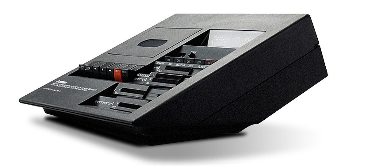 An image of an old-fashioned cassette player. It is designed so that it sits at a 30-degree angle up form the surface it's placed on.