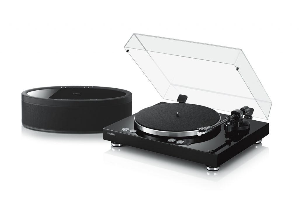 An image of a turntable next to a high-quality speaker.