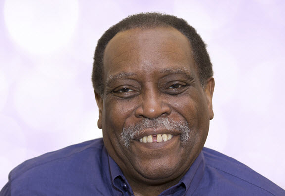 Headshot of an older African American man smiling.