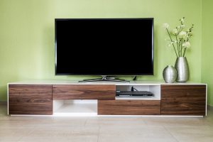 Large flat screen tv on a stand on a console with components below.