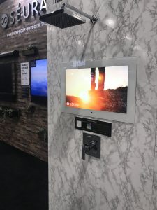 Flat screen displayed in a wall with controls below.