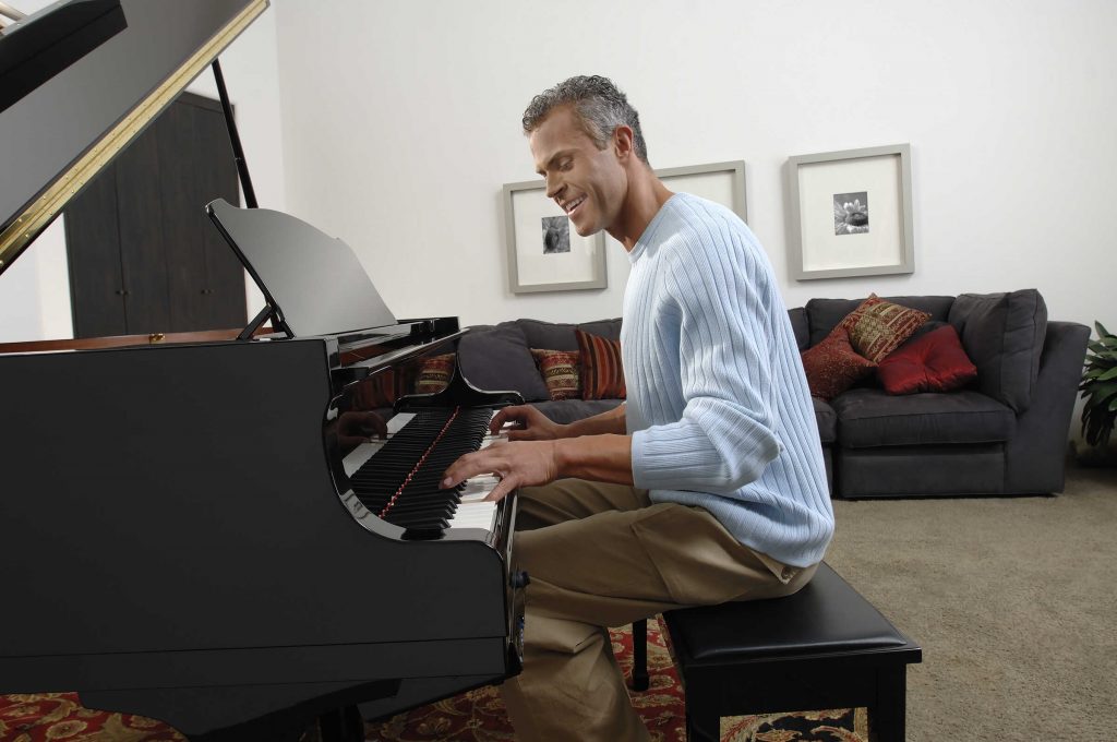 Man playing a grand piano.