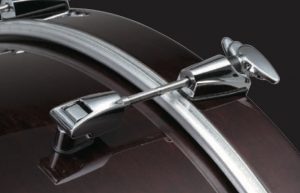 Close-up shot of silver bass drum claw on deep read bass drum.