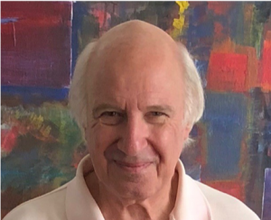 Smiling older caucasian male in front of abstract painting.