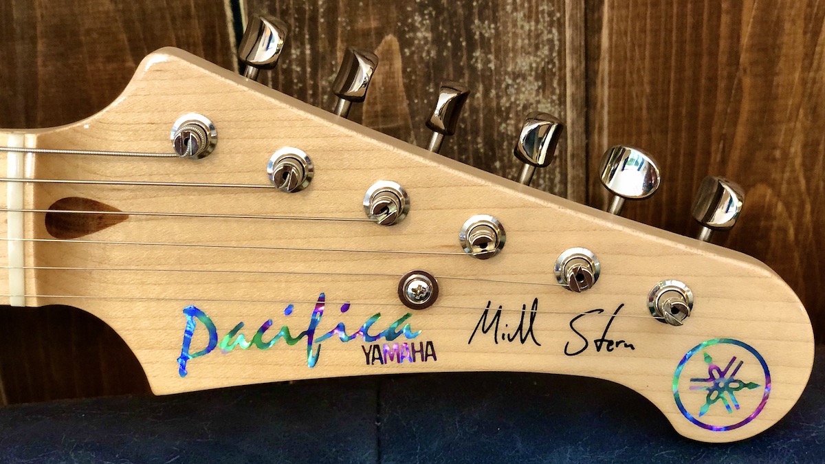 Electric guitar headstock with Mike Stern’s signature and abalone inlays.