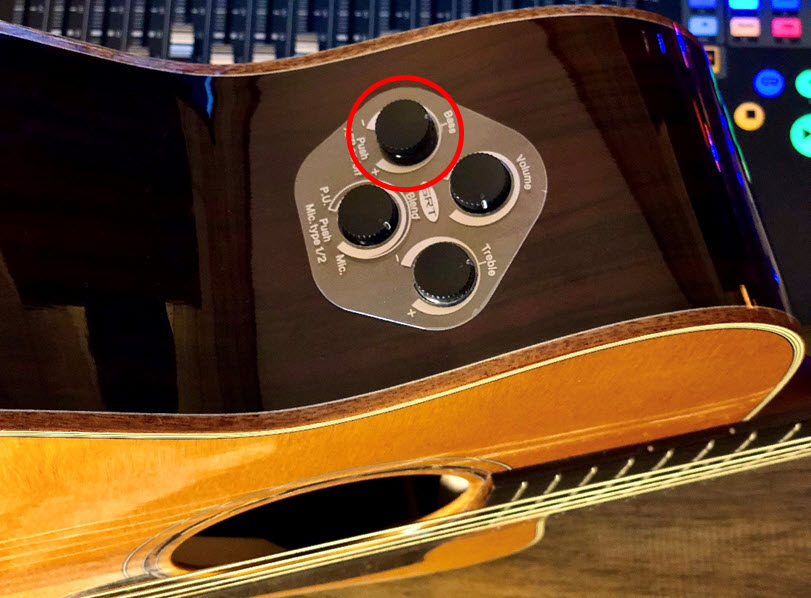 Closeup of bass control on side of guitar body.