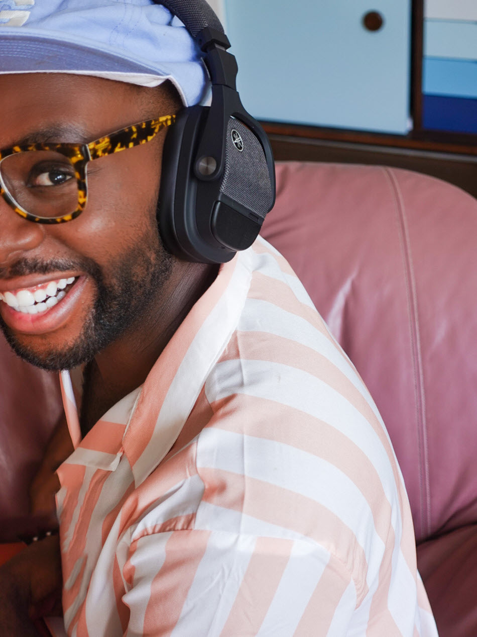 Young man smiling while wearing over the head headphones.