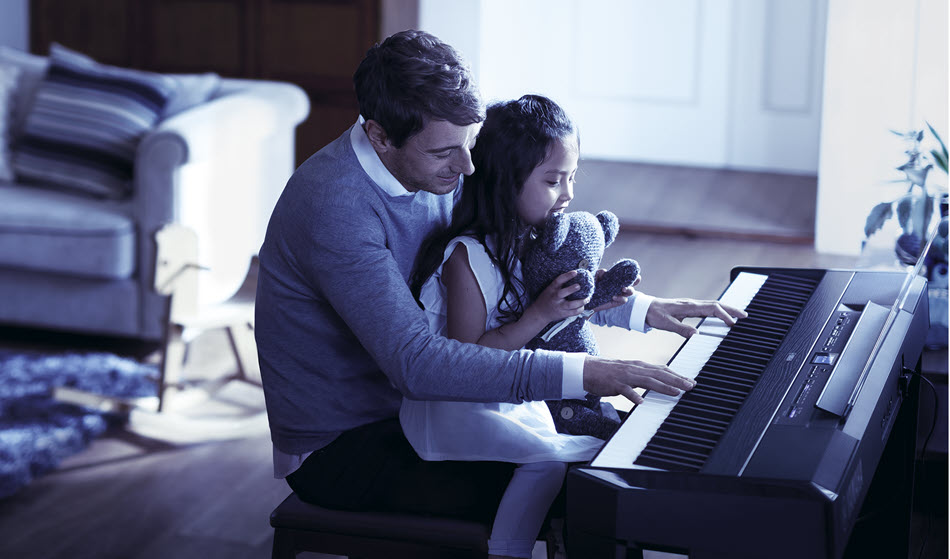 Father and daughter at keyboard.