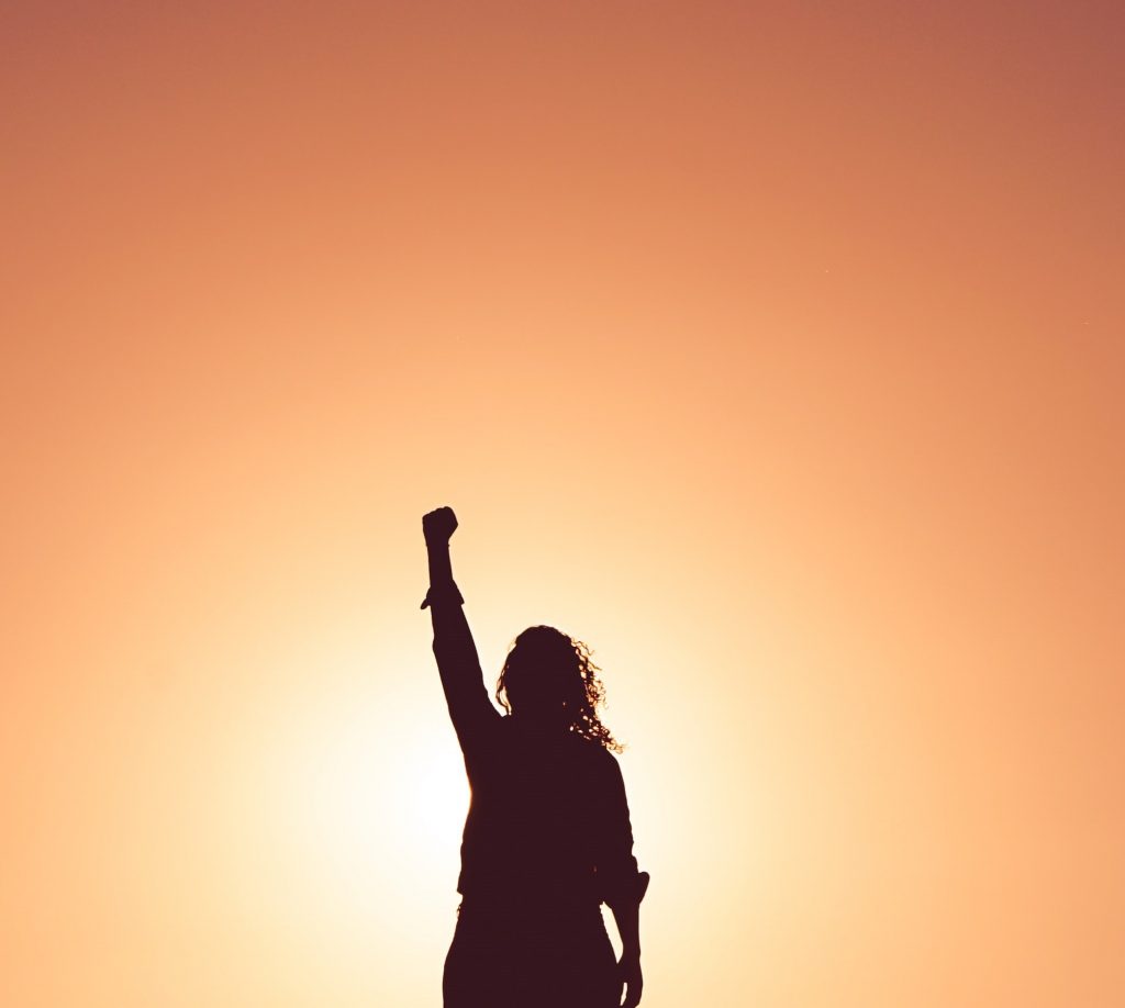silhouette of woman with one arm raised