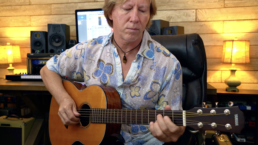 Author in his studio playing acoustic guitar.