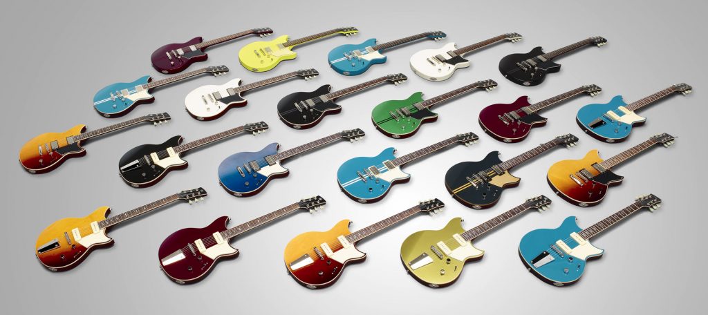 Staggered rows of beautiful electric guitars laying flat with strings up in a variety of colors.
