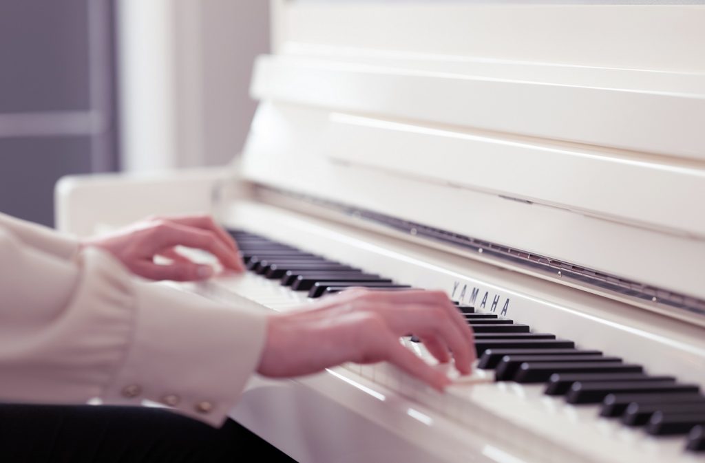 woman playing white piano