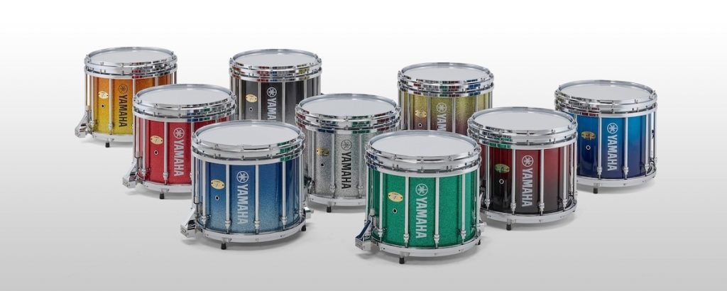 Brightly colored individual Yamaha snare drums in staggered rows.