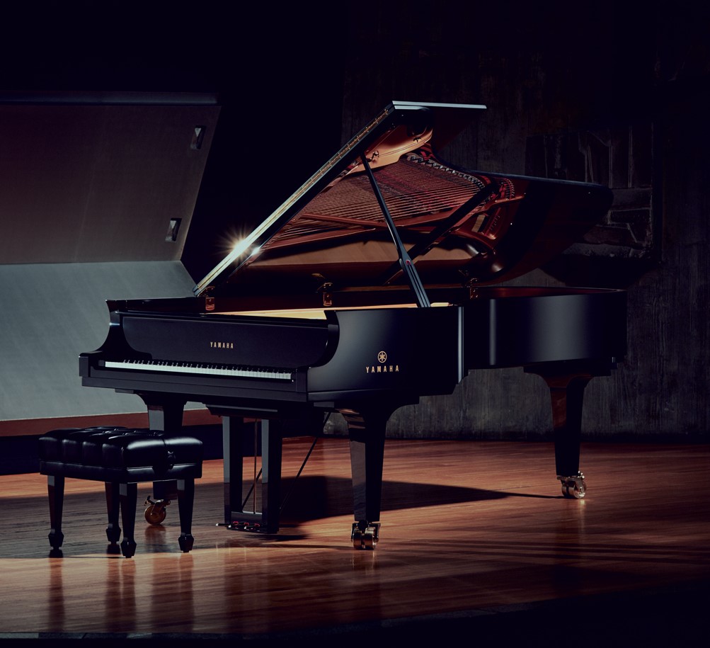 Yamaha concert grand piano center stage.